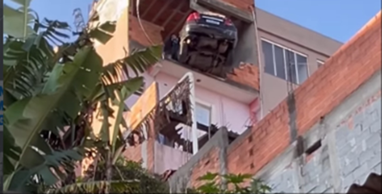 Imagem destacada do post: Motorista perde controle do veículo durante ré e carro fica pendurado no muro